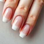 Classic french tip acrylic nails with perfect white tips on almond-shaped nails