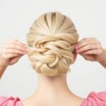 Woman styling a blonde wig into a simple updo hairstyle