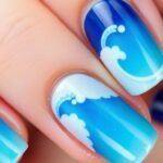 Blue ombre ocean wave nail design with white caps and subtle shimmer for beach nail inspo