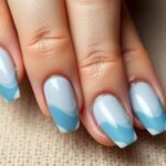 Elegant hands with classy beach nails featuring subtle wave designs in soft blue tones