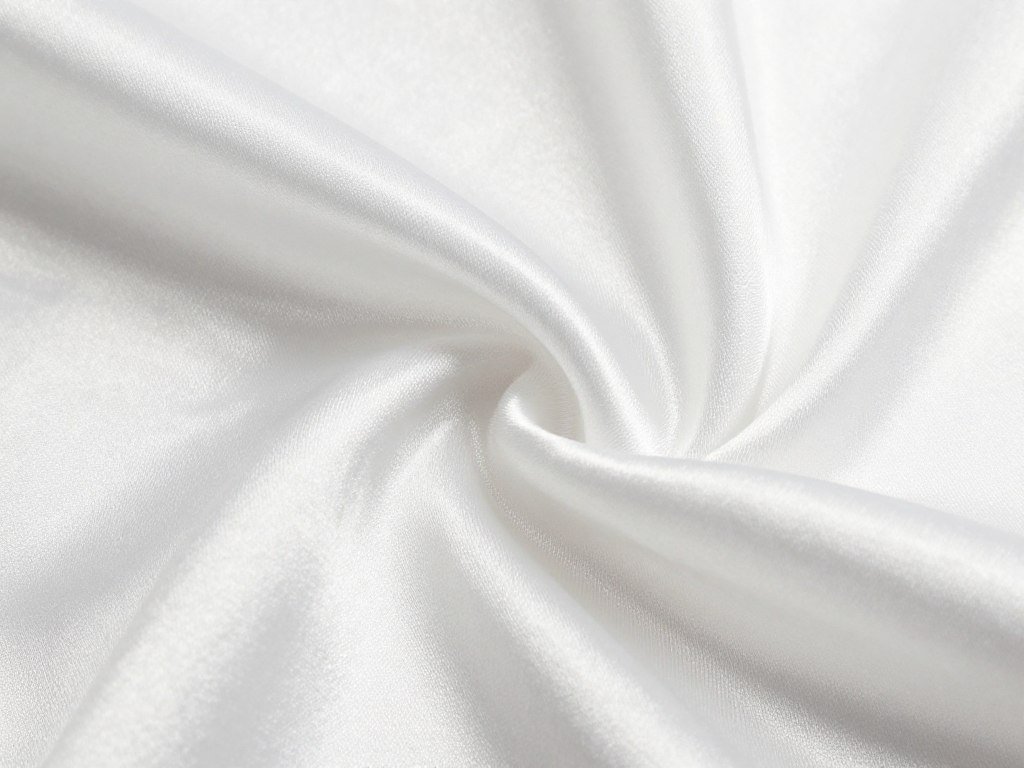 Close-up detail of white satin fabric showing its characteristic sheen and smooth texture