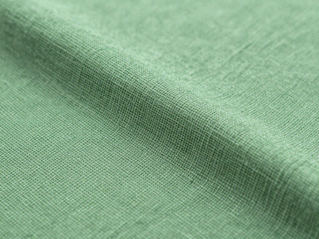 Close-up of green linen pants fabric texture showing the natural weave pattern