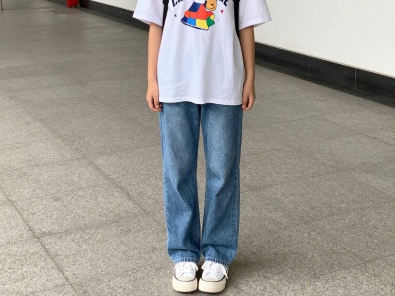 Girl wearing oversized graphic tee with straight-leg jeans and white sneakers for a casual school outfit