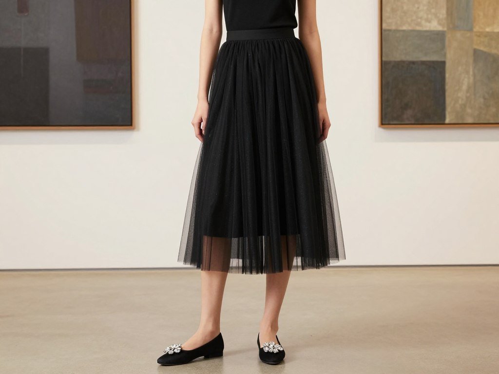 Woman in black tulle midi skirt with fitted top and embellished flats