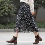 Woman wearing a floral maxi skirt with a light sweater for spring