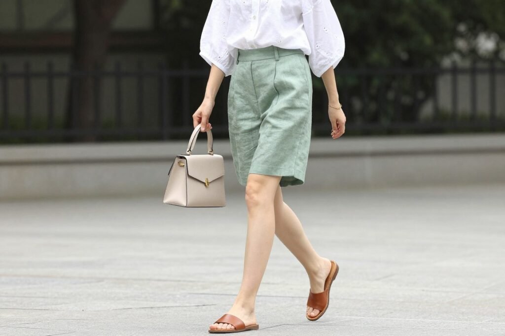 Woman wearing comfy casual summer outfit with dressy shorts and blouse