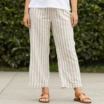 Woman wearing striped linen pants with a simple white t-shirt and sandals, showcasing the versatility of striped linen pants outfits
