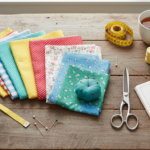 colorful fabric pieces and sewing supplies arranged on a wooden table