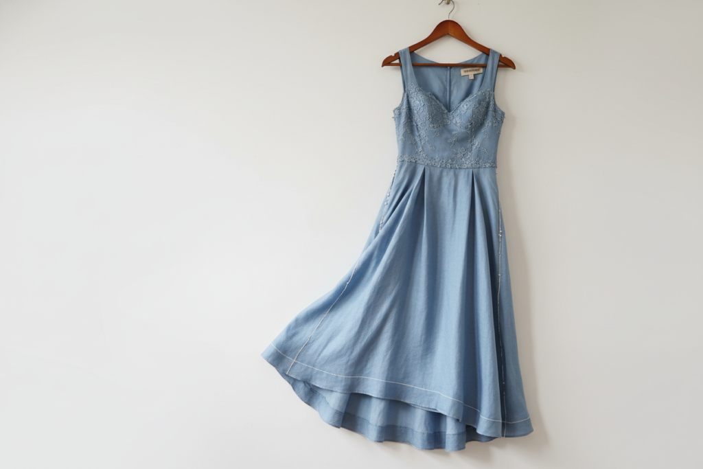 finished handmade dress hanging on hanger