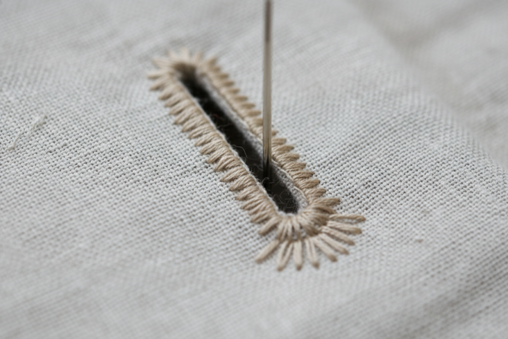 hand-sewn buttonhole detail on fabric