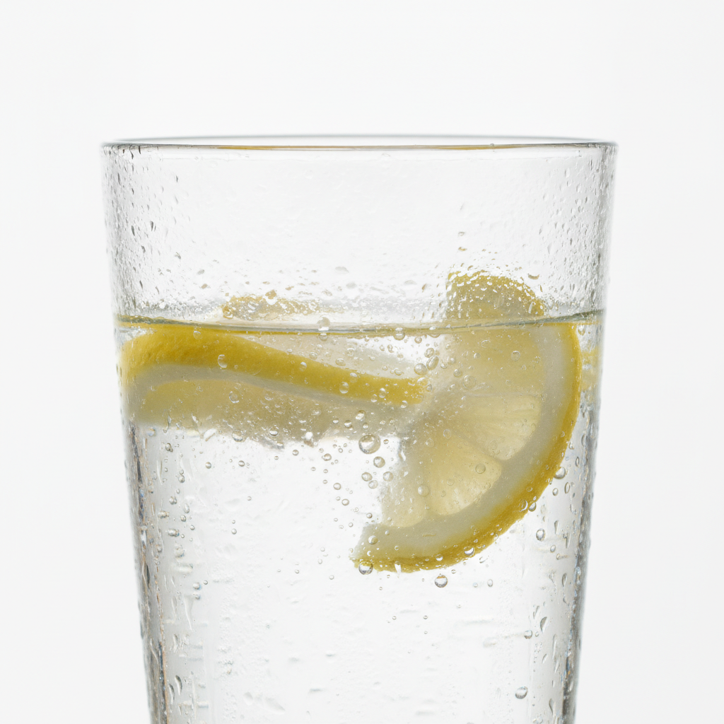 Glass of fresh water with lemon slices for skin hydration